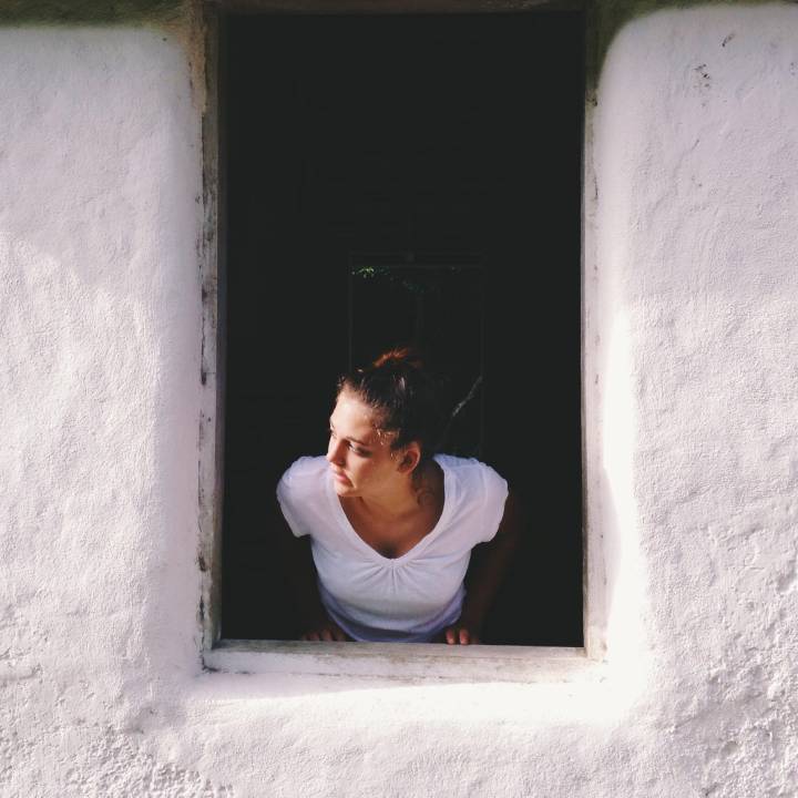 woman looking out of an open window